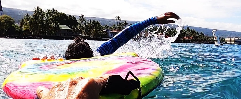 Woman taking swimming lessons to learn to swim with dolphins, Hawaii.