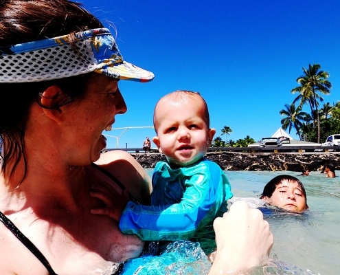 Child swim instructor holding one of her students.